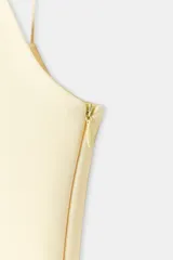 Top negro ajustado al cuerpo con escote recto y tirantes finos. Presenta un bajo con corte peplum.