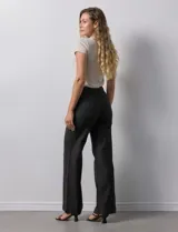 Jean de tiro alto con corte wide leg, color blanco. Presenta pretina con pasadores, cierre frontal con botón y bolsillos funcionales tanto en la parte delantera como en la trasera.