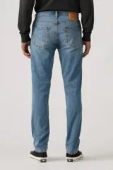 Jean de corte slim fit, color celeste, con cierre de cremallera y botón metálico. Presenta un diseño clásico de cinco bolsillos con costuras reforzadas.
