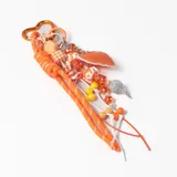 Llavero decorativo en tonos naranja, compuesto por una cuerda trenzada, un mosquetón en forma de corazón y múltiples dijes colgantes que incluyen cuentas de cristal, figuras de flores, un dije de corazón de cuero sintético y una esfera brillante.