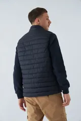 Chaleco negro de nylon para hombre, con cierre frontal, cuello alto y bolsillos laterales con cierre.