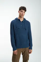 Buzo de punto azul con capucha, cordón ajustable, cierre parcial con botones y bolsillo tipo canguro.