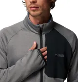 Campera técnica de polar Columbia Titanium, color gris con textura microperforada y panel frontal superior en negro. Cuenta con cierre frontal completo, cuello alto, bolsillo en el pecho con cierre, mangas largas con orificios para pulgares y ribetes elásticos en puños y dobladillo.