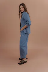 Chaqueta de jean azul, de corte entallado, con cuello camisero, cierre frontal con botones y bolsillos delanteros con solapa.