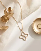 Collar de bronce con baño de oro, compuesto por una cadena fina y un dije colgante en forma de trébol de cuatro hojas o flor, adornado con circonias incrustadas.