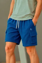 Bermuda cargo de tejido waffle en color azul, con bolsillos laterales con solapa y cordón ajustable en la cintura.