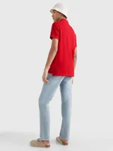 Chomba roja Tommy Hilfiger 1985 de corte regular, con cuello tipo chomba, cartera de dos botones, logo de Tommy Hilfiger bordado en el pecho y detalles distintivos de la marca.