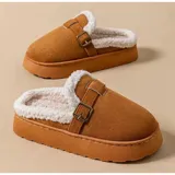 Pantuflas sin talón de gamuza marrón, con interior de corderito sintético, suela plataforma y tira ajustable con hebilla en el empeine.