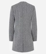 Tapado alargado de poliéster con estampa zigzag en blanco y negro. Tiene cuello redondo, cierre abotonado, mangas largas y bolsillos con cierre.