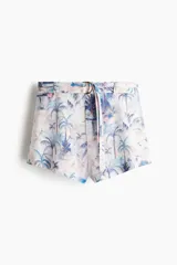Short de viscosa y algodón con estampado tropical de palmeras en tonos celestes y rosados, de corte holgado, tiro superalto y cinturón con argollas metálicas en D.