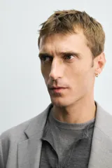 Blazer slim fit de color gris, confeccionada en tejido con lana. Presenta cuello con solapas de muesca, cierre frontal con un botón, bolsillos de solapa en la cadera y bolsillo de vivo en el pecho.