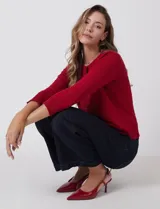 Cardigan de tejido fino en color rojo, con cuello redondo, cierre frontal con botones y mangas tres cuartos con puños acanalados.