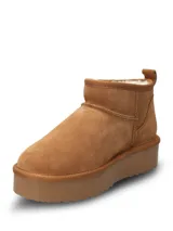 Bota corta de gamuza color camel con interior forrado en piel sintética y suela de plataforma de goma al tono.