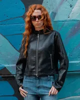 Campera de cuero sintético negro estilo motero con cuello mao, cierre frontal, bolsillos con cierre y detalles de tachas en hombros y mangas.