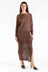 Falda midi tejida color marrón chocolate, con diseño calado en la parte inferior y tajo trasero.