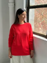 Sweater de punto color rojo con diseño de rombos en relieve, cuello redondo y mangas largas con puños acanalados.