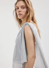 Poncho gris de punto con diseño asimétrico de capa, cuello barco y mangas tres cuartos.