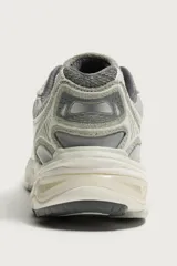 Zapatilla deportiva tipo running color marrón, con parte superior confeccionada en combinación de piezas de malla, gamuza y material sintético. Posee suela con volumen y diseño irregular.