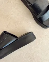 Sandalias negras de cuero vacuno con plataforma y tiras regulables con velcro.