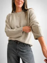 Sweater de punto de diseño minimalista, con cuello redondo y mangas largas. Presenta un corte holgado y textura suave, ideal para un estilo versátil y atemporal.