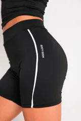 Calza corta negra de lycra suplex con cintura alta y una franja vertical blanca en el lateral.