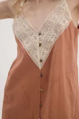 Vestido lencero de lino color marrón, de corte recto, con escote en V y aplicación de encaje beige en la parte superior. Cuenta con tirantes finos regulables y una hilera de botones decorativos en el frente.