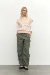 Chaleco de tweed color salmón con diseño a cuadros, sin mangas, con bolsillos frontales y botones perlados.