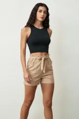 Short de tiro alto con estampado botánico en tonos verdes y crudos. Presenta una cintura elástica con lazo ajustable del mismo tejido, bolsillos laterales y un corte holgado.