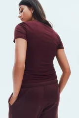 Remera de manga corta, color bordó, con cuello redondo y corte entallado.