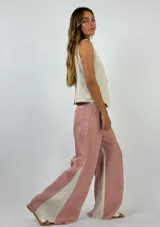 Pantalón de lino color marrón con paneles laterales en color crema y corte acampanado.