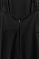 Vestido midi de gabardina en color negro, con cuello halter, tirantes finos y falda con vuelo. Cuenta con cierre en la espalda con cremallera oculta.