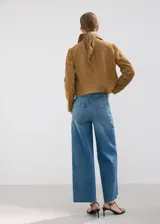 Jeans de denim azul de tiro medio, corte wide leg y diseño de pernera ancha con terminación deshilachada en el bajo.