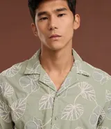 Camisa de calce comfort de la marca Marfinno, confeccionada en algodón color verde con bordado de hojas blancas. Posee cuello con solapa, manga corta y cierre frontal con botones.