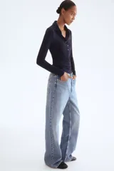 Remera polo de manga larga, color azul marino oscuro, confeccionada en tejido de punto acanalado. Presenta cuello clásico y tapeta frontal con botones dorados.