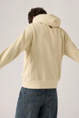 Buzo hoodie color crema con logo bordado en el pecho y bolsillo tipo canguro.