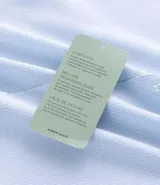 Camisa de manga larga color celeste, con cuello inglés y abotonado delantero. Confeccionada en tricolina con fibra de bambú, presenta un diseño maquinetado con estampado de rayas.