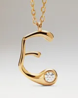 Collar dorado con cadena de eslabones y colgante en forma de la letra E, decorado con una circonita incrustada.
