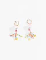 Par de aros colgantes con argolla dorada, perla blanca y colgantes de mostacillas de colores formando figuras humanas.