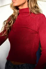 Polera de tejido acanalado color azul, de corte ajustado con cuello alto y mangas largas.