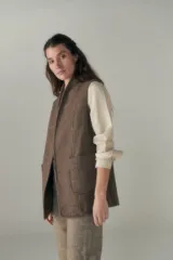 Chaleco color crema con solapas, corte entallado y bolsillos plaqué.