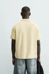 Polo de hombre color verde oliva, de corte regular fit, con cuello solapa y cierre frontal de botonadura. Presenta manga corta y acabados en rib.