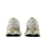 Championes urbanos New Balance modelo 9060, de diseño chunky en tonos blancos y crudos con detalles plateados. Combinan malla y superposiciones de gamuza, con la clásica "N" en el lateral y una entresuela esculpida distintiva.