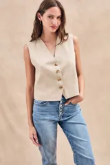 Chaleco color beige con escote en V y botones frontales.