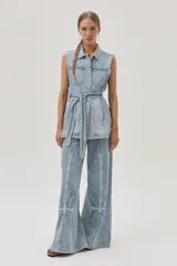 Jean de calce recto y tiro medio-alto, color celeste claro, con bordado a lo largo de la pierna.