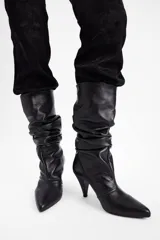 Bota de caña media en cuero negro con diseño slouchy, punta fina y taco cónico de altura media.