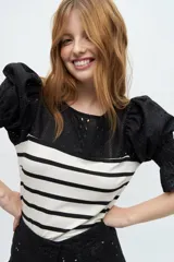 Blusa negra con mangas cortas fruncidas y escote redondo con detalles de lino broderie.