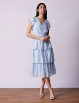 Vestido midi celeste de gasa estampada, marca Julia Jordan. Tiene escote en V, mangas cortas con volados y forro interno a tono.