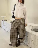 Pantalon de corte holgado y tiro medio con estampado de cuadros en tonos marrones y grises. Presenta cintura elástica y diseño de pierna ancha.