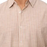 Camisa de manga corta color beige con rayas verticales blancas, cuello clásico y cierre con botones.