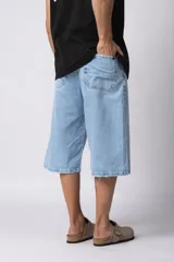 Bermuda de jean con corte baggy y lavado vintage en tono marrón oscuro. Presenta un diseño amplio y cómodo con bordes deshilachados en el ruedo, evocando un estilo nostálgico de los años 2000.